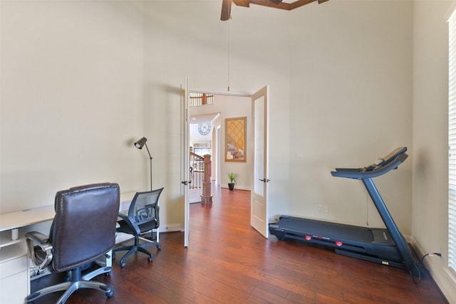 office area with a high ceiling, ceiling fan, and dark hardwood / wood-style flooring