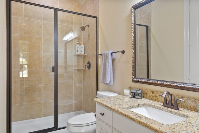 bathroom featuring toilet, vanity, and walk in shower