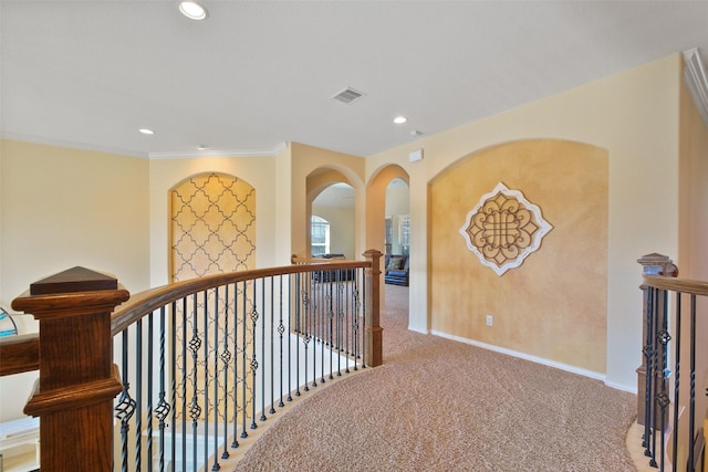 hall with ornamental molding and carpet flooring