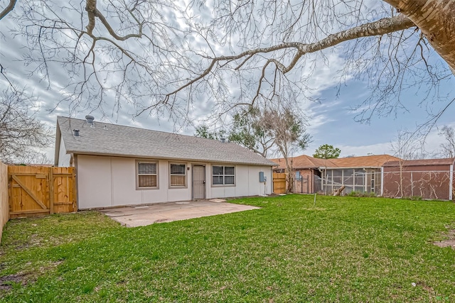 back of house with a fenced backyard, a gate, a lawn, and a patio