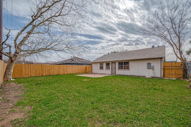 rear view of house with a yard, a fenced backyard, and a patio