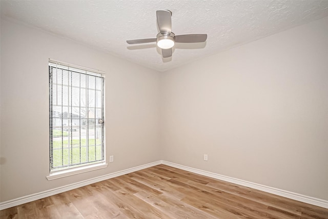 unfurnished room with a ceiling fan, light wood-style flooring, baseboards, and a textured ceiling