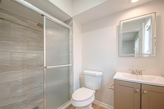 bathroom featuring tiled shower, vanity, toilet, and baseboards