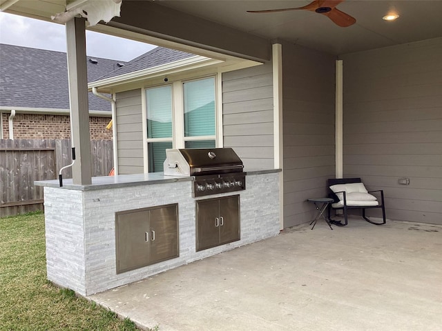 view of patio with ceiling fan, a grill, and exterior kitchen