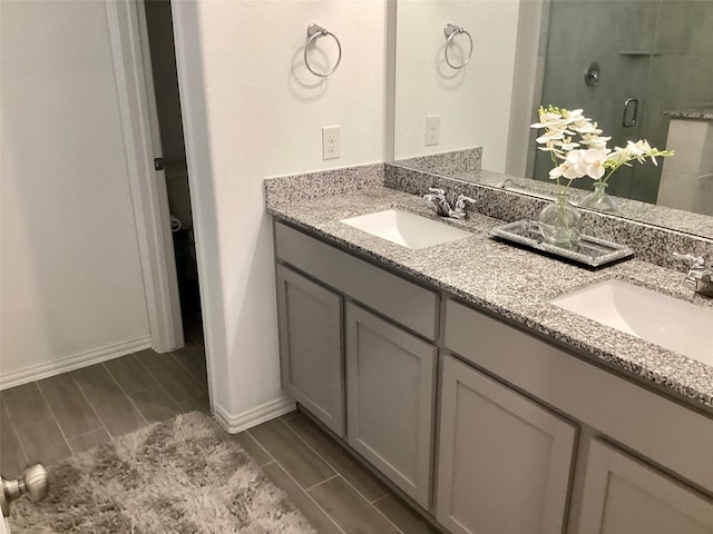 bathroom with a shower with door and vanity