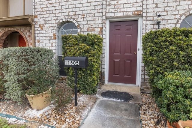 entrance to property featuring brick siding