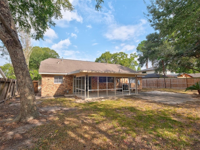 back of house with a patio area and a lawn