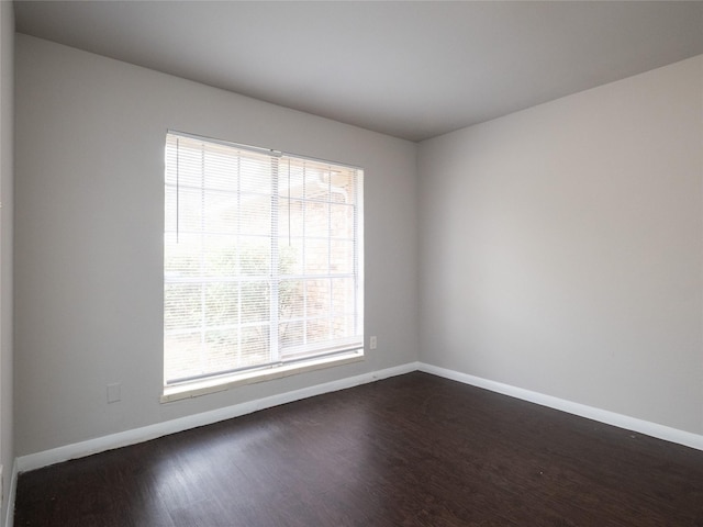 empty room with dark hardwood / wood-style flooring