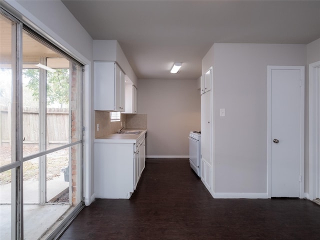 kitchen featuring white range with gas stovetop, backsplash, sink, white cabinetry, and dark hardwood / wood-style floors