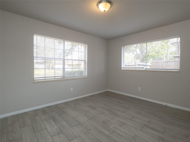 empty room with hardwood / wood-style flooring and a healthy amount of sunlight