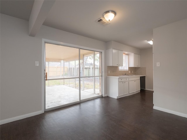 kitchen featuring backsplash, white cabinetry, beamed ceiling, dishwasher, and dark hardwood / wood-style floors