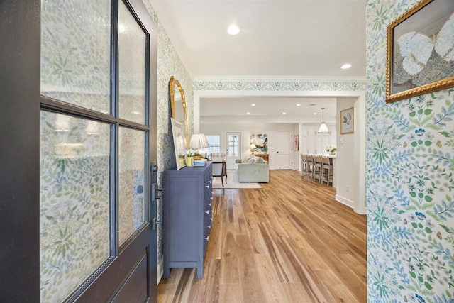 foyer entrance with ornamental molding and hardwood / wood-style floors