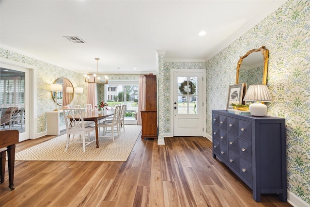 dining space featuring a notable chandelier, crown molding, and dark hardwood / wood-style floors