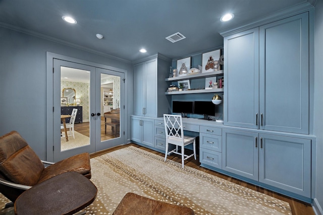 office featuring dark hardwood / wood-style flooring, crown molding, built in desk, and french doors