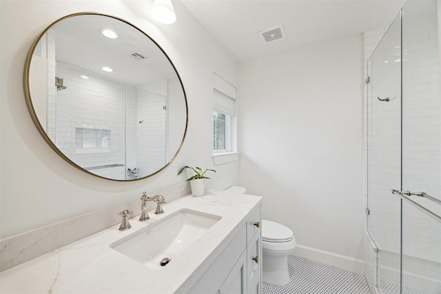 bathroom featuring toilet, a shower with door, tile patterned flooring, and vanity