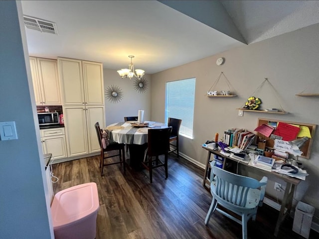 dining room with dark hardwood / wood-style floors and an inviting chandelier