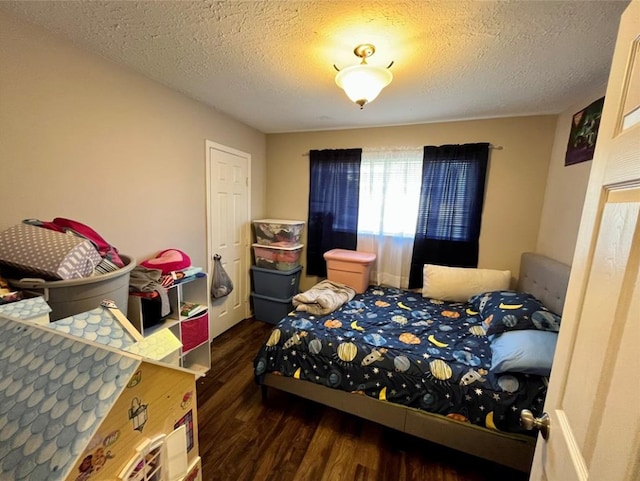 bedroom with a textured ceiling and dark hardwood / wood-style floors