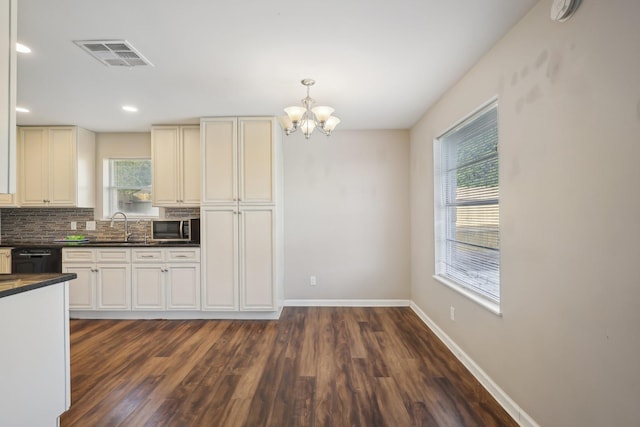 kitchen with visible vents, a chandelier, stainless steel microwave, dark countertops, and dark wood-style flooring