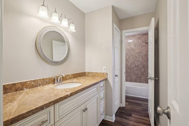 bathroom featuring wood finished floors, vanity, and shower / tub combination