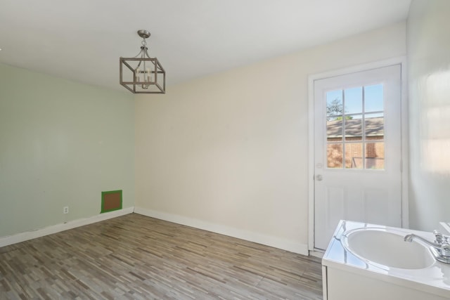 dining room featuring a chandelier, light wood finished floors, and baseboards