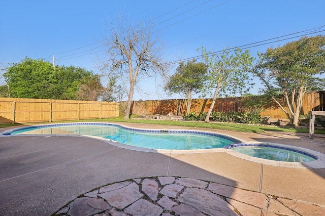 view of pool with a patio area, a fenced backyard, and a pool with connected hot tub