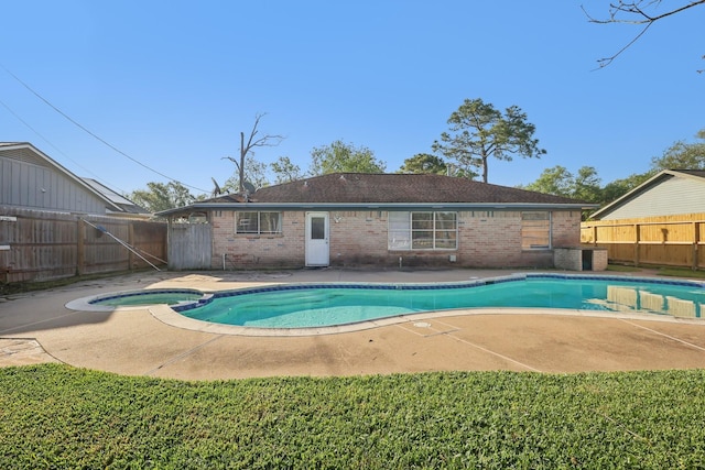 view of swimming pool featuring a patio area, a pool with connected hot tub, and a fenced backyard