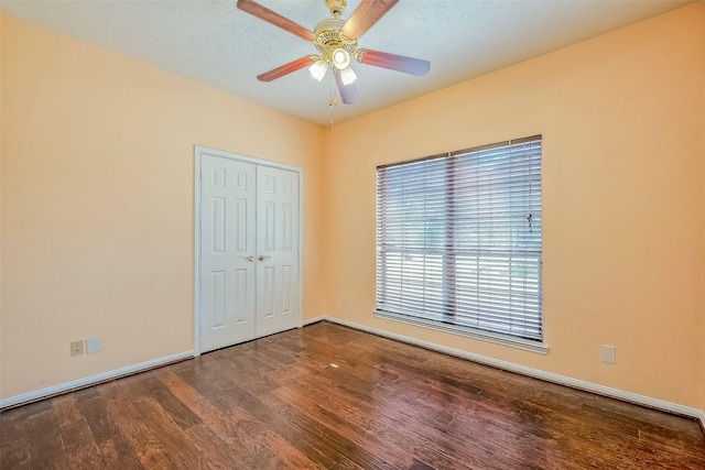 unfurnished bedroom with ceiling fan, a textured ceiling, a closet, and hardwood / wood-style floors