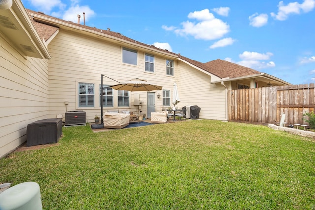 back of property with central AC unit and a lawn