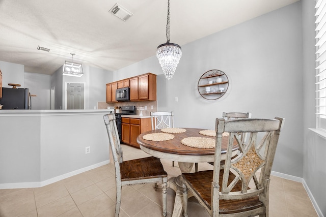 dining area with light tile patterned flooring and an inviting chandelier