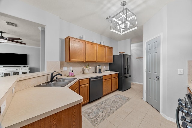 kitchen with sink, stove, dishwasher, black fridge, and decorative light fixtures