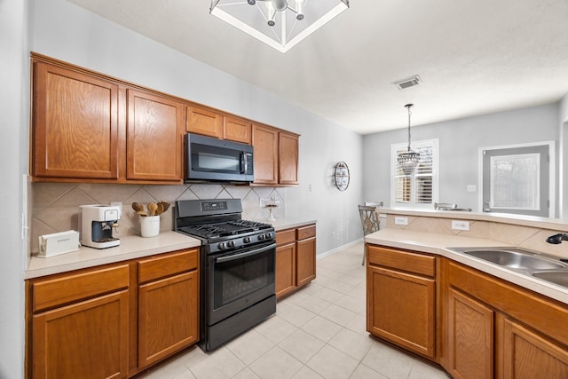 kitchen with light tile patterned floors, sink, backsplash, pendant lighting, and black range with gas cooktop