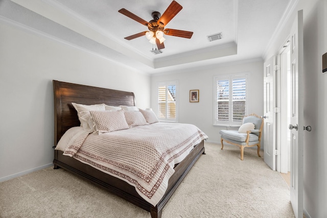 carpeted bedroom featuring a tray ceiling, ceiling fan, and crown molding