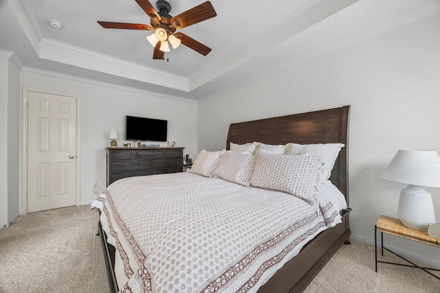 bedroom featuring a tray ceiling, ceiling fan, crown molding, and light carpet