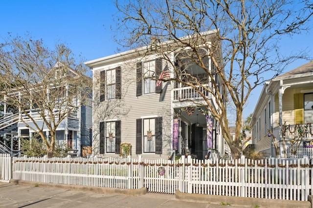 view of front of property featuring a fenced front yard and a balcony