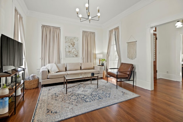 living room with a chandelier, ornamental molding, baseboards, and wood finished floors