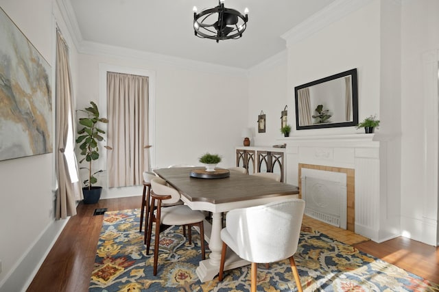 dining space with a chandelier, ornamental molding, wood finished floors, and baseboards