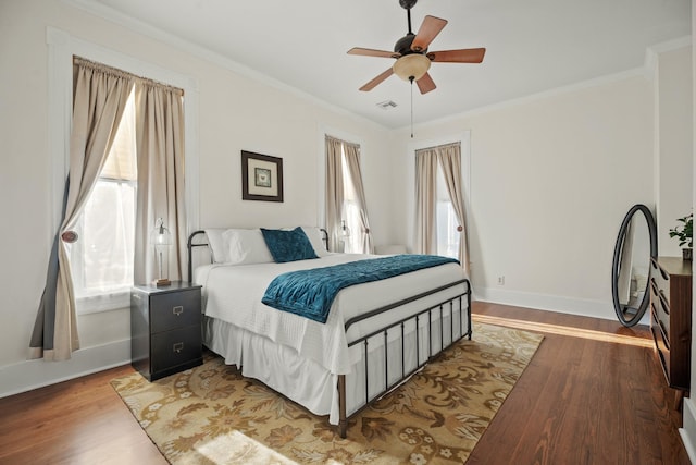 bedroom with multiple windows, crown molding, and wood finished floors