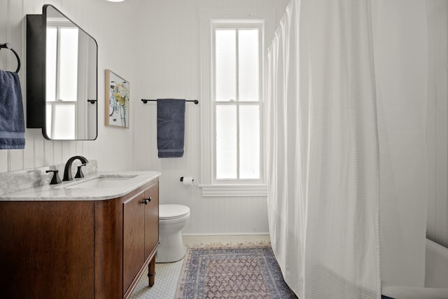 bathroom featuring curtained shower, vanity, toilet, and tile patterned floors