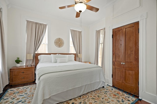 bedroom featuring light wood-style floors, a ceiling fan, and crown molding