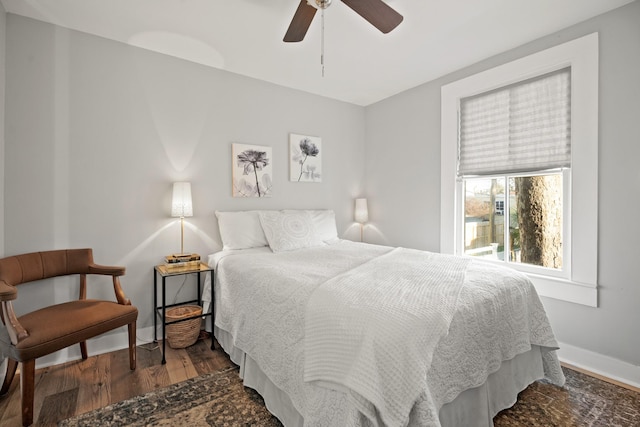 bedroom with a ceiling fan, baseboards, and wood finished floors