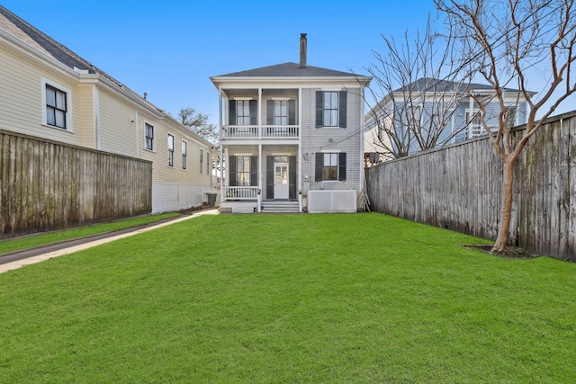 view of front of home with a balcony, a fenced backyard, and a front lawn