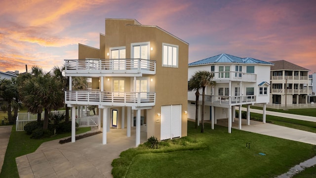 view of front of property featuring a carport, driveway, a balcony, and stucco siding