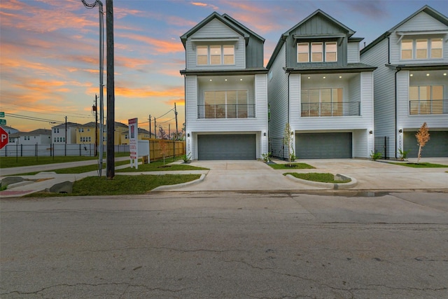 view of front of house featuring board and batten siding, fence, driveway, and an attached garage