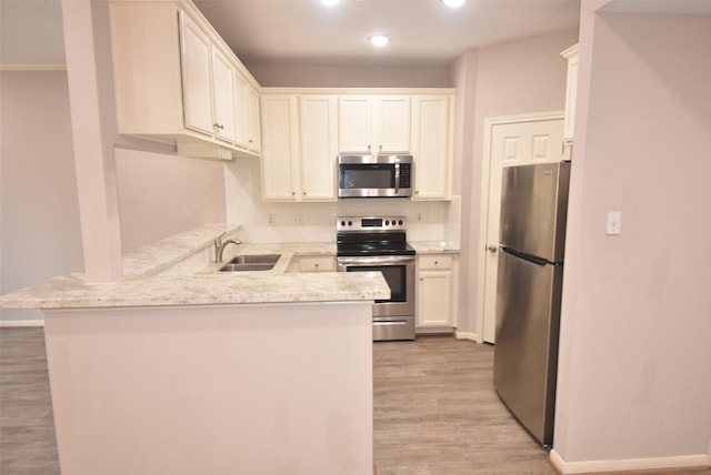 12565 Melville Dr Unit 224, Montgomery, TX 77356 - kitchen featuring kitchen peninsula, light hardwood / wood-style floors, sink, appliances with stainless steel finishes, and white cabinets