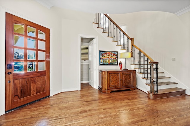 entryway featuring stairway, baseboards, light wood-style floors, and arched walkways