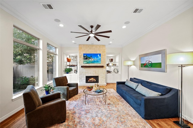 living area featuring crown molding, wood finished floors, and visible vents