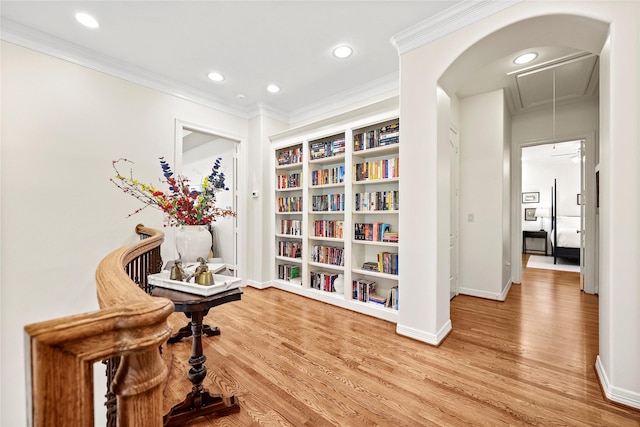 sitting room with attic access, crown molding, and wood finished floors