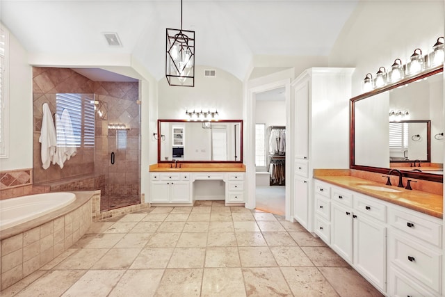 bathroom with vanity, a shower stall, a garden tub, and visible vents