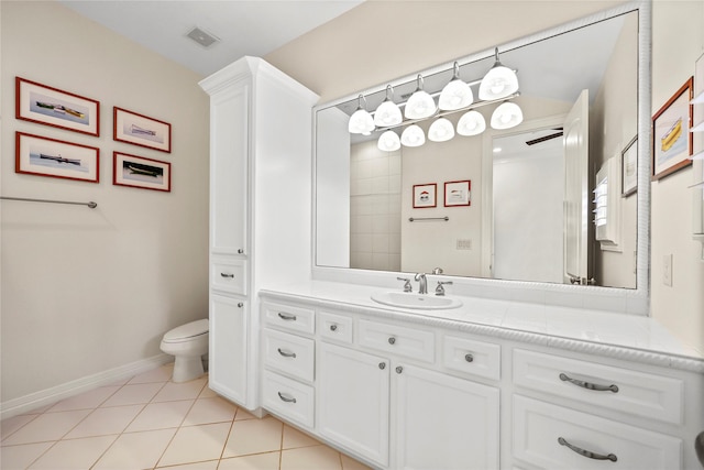 bathroom with vanity, visible vents, baseboards, tile patterned flooring, and toilet