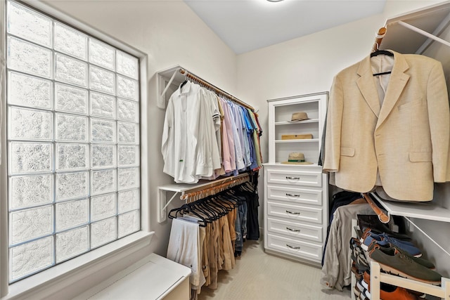 walk in closet featuring light colored carpet